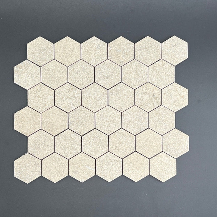 Mocha cream limestone antique Chanteau hexagon mosaic tile, 2x2 inches, from TILE AND MOSAIC DEPOT, showcasing a decorative stone pattern.