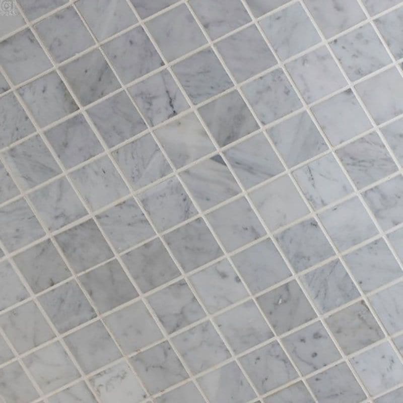 White Carrara marble 2x2 honed mosaic tile showing polished square tiles with natural gray veining for elegant surface design.